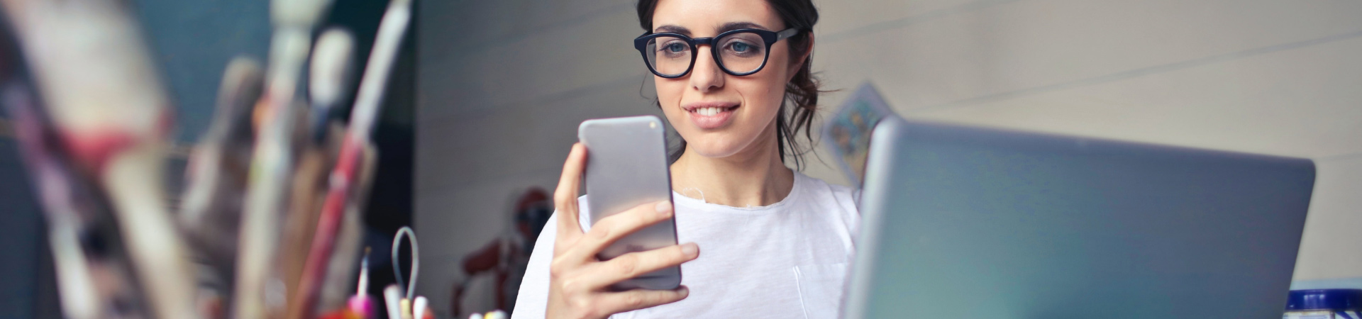 Woman with a smartphone at the laptop